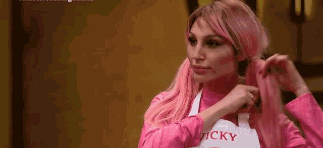 a woman with pink hair is wearing an apron that says vicky .