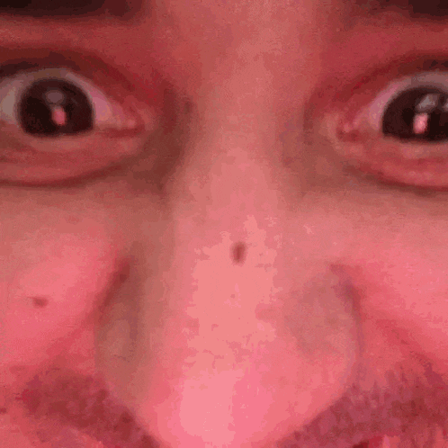 a close up of a person 's eyes and nose with a pink background .
