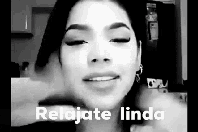 a black and white photo of a woman 's face with the words `` relajate linda '' written on it .
