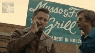 two men are standing in front of a sign that says musso & grill