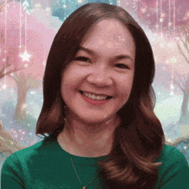 a woman in a green shirt smiles in front of a pink background