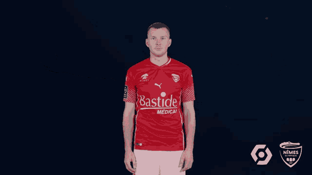 a man wearing a red bastide medical jersey