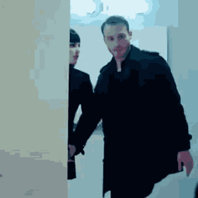 a man and woman are standing next to each other in a doorway .