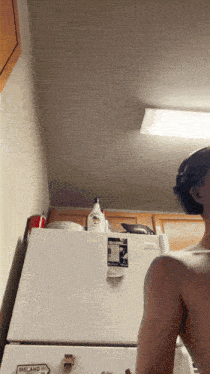 a woman stands in front of a refrigerator that says ireland on it