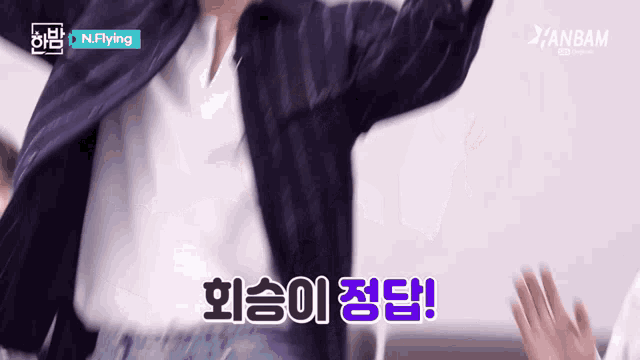 a man in a suit is giving a high five in a video sponsored by n.flying