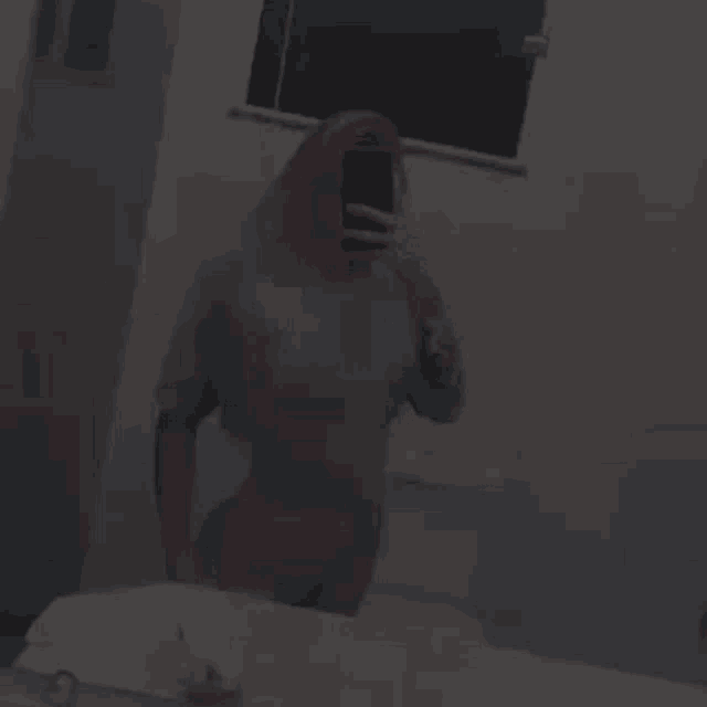 a woman taking a selfie in a bathroom mirror