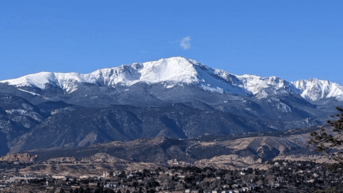 a mountain covered in snow with a blue sky behind it