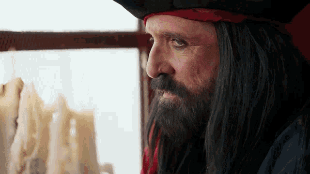 a man in a pirate costume looks at candles