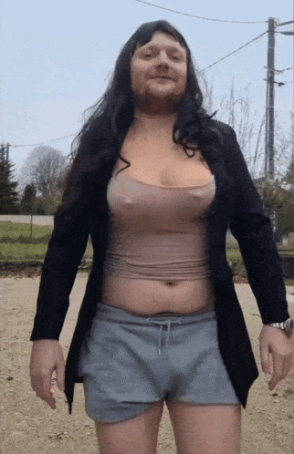 a man with a beard is wearing shorts and a crop top