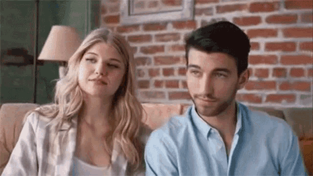 a man and a woman are sitting on a couch in a living room .
