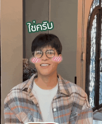 a man wearing glasses and a plaid shirt has a sticker on his face that says ' i 'm happy '