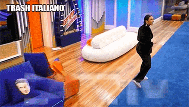 a woman is jumping in the air in a room with trash italiano written on the bottom