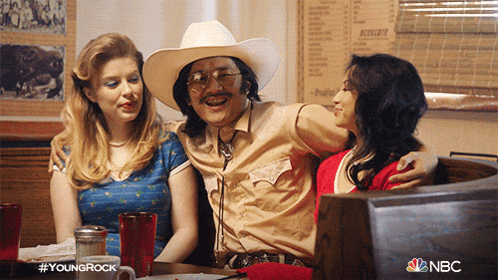 a man in a cowboy hat sits between two women at a table with nbc written on the bottom