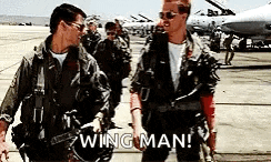 a group of men in military uniforms are walking down a runway holding hands .