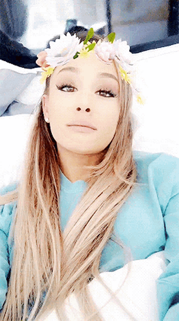 ariana grande is wearing a floral crown on her head .
