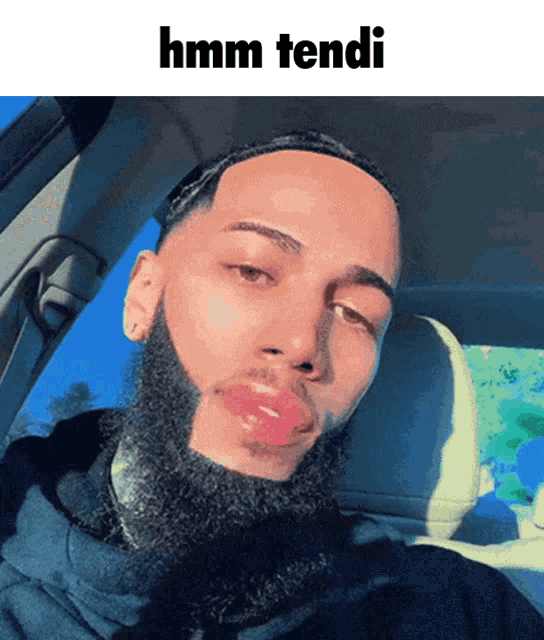 a man with a beard and red lips is sitting in a car with the caption hmm fendi