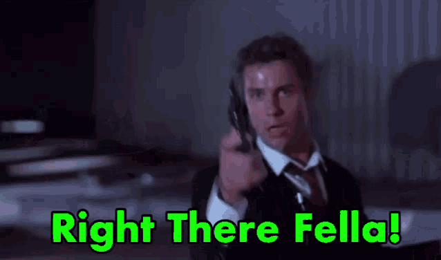 a man in a suit and tie is pointing a gun at someone and says `` right there fella '' .