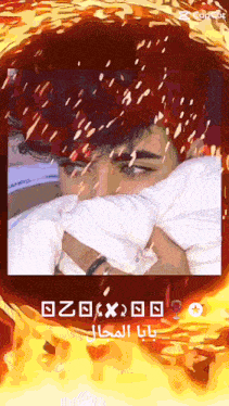 a picture of a man with red hair is surrounded by flames and arabic writing