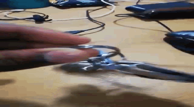a close up of a person 's hand holding a piece of wire .