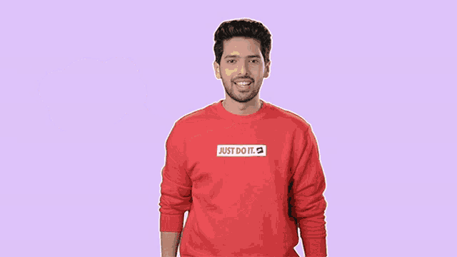 a man wearing a red shirt that says just do it on it