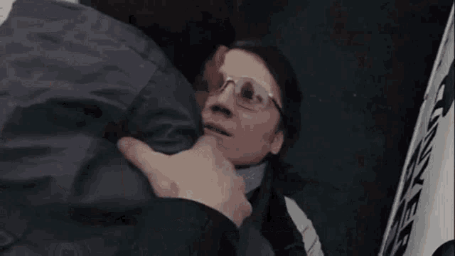 two men are hugging each other and one of them is wearing glasses and the other is wearing a tie .