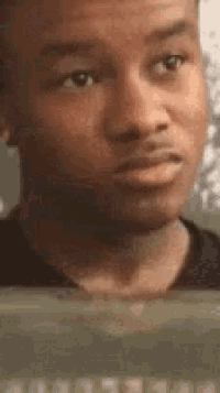 a man is making a funny face while looking at a computer screen .