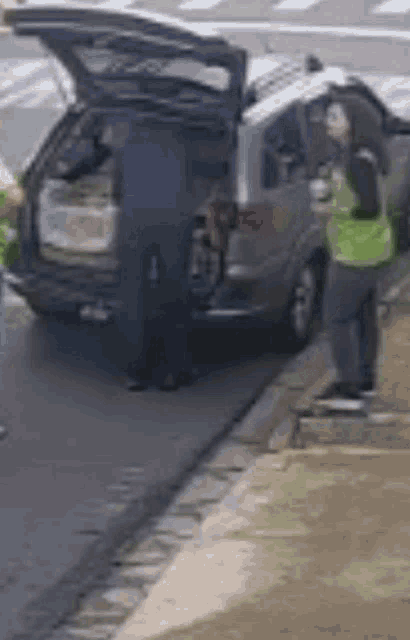 a man is loading groceries into the back of a car .
