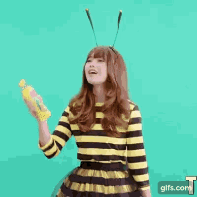 a woman in a bee costume is holding a bottle of juice .