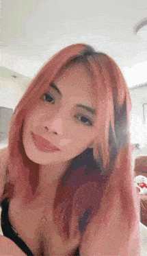 a woman with red hair and a black bra is smiling