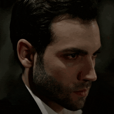 a man with a beard looks at the camera with a serious look on his face
