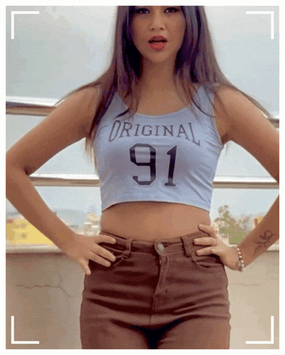 a woman is wearing a crop top with the number 91 on it