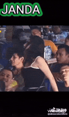 a woman is dancing in a crowd of people at a bar .