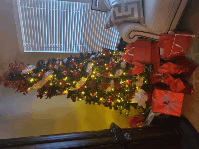 a christmas tree with lots of presents underneath it in a living room