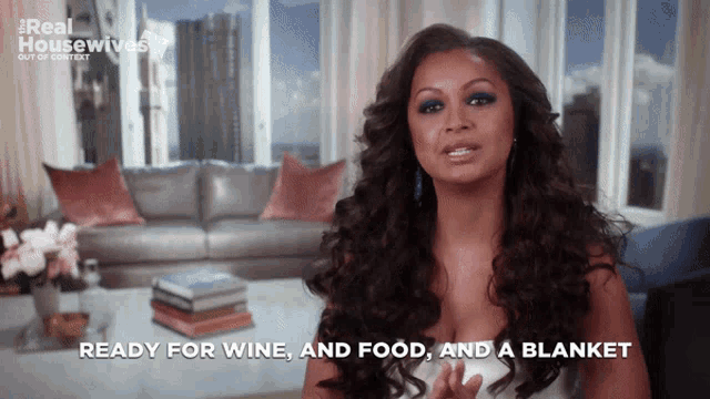 a woman in a living room with the words ready for wine and food and a blanket