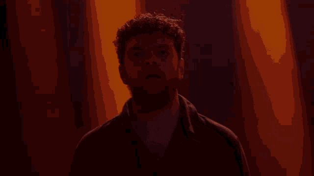 a man with a beard is standing in the dark