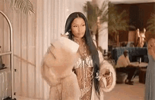 a woman is wearing a fur coat and holding a purse .