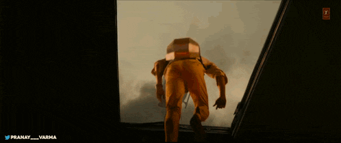 a man with a box on his back is walking through a doorway with the words pranay and varma below him