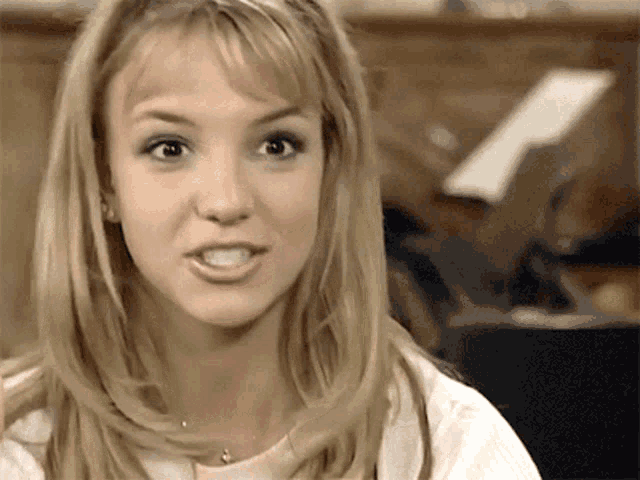a close up of a blonde woman 's face with a smile on her face