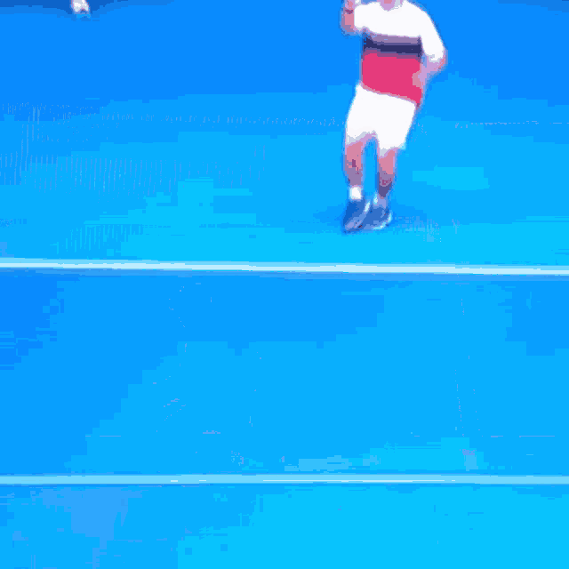 a man holding a tennis racquet on a blue court with a kia logo in the background