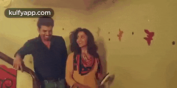 a man and a woman are standing next to each other on a staircase in a room .