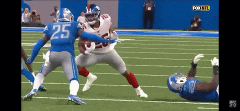 a football player with the number 25 on his jersey runs with the ball