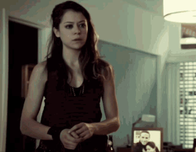 a woman standing in front of a picture of a man and a woman