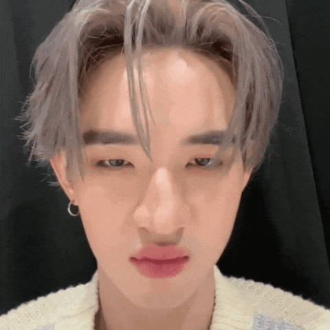 a close up of a person 's face with gray hair and red lips