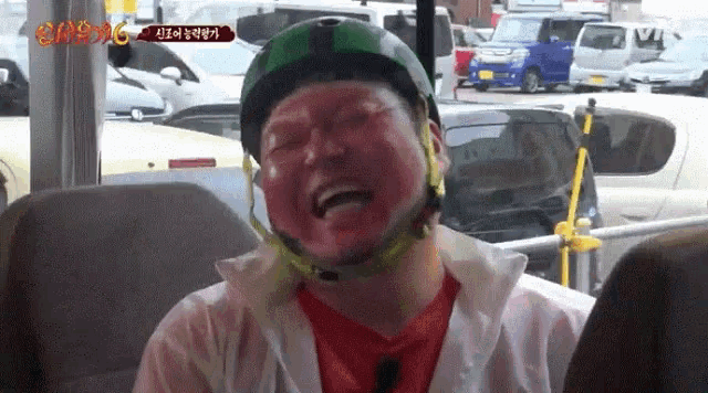 a man wearing a helmet with red paint on his face