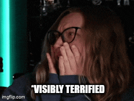 a woman with glasses is covering her mouth with her hands and the words " visibly terrified " are written below her