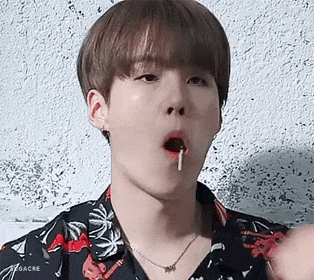 a close up of a young man eating a lollipop .