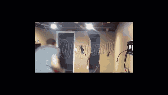 a man is standing in a room with a pool table and a sign on the wall that says " controlazar "