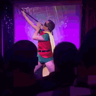 a man dressed as robin is holding a spear in front of a crowd