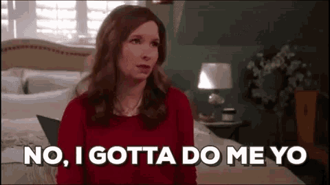 a woman in a red sweater is sitting on a bed and saying no , i gotta do me yo .