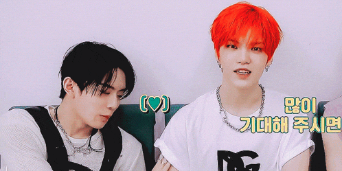 two boys with red hair are sitting next to each other and one has a heart on his chest